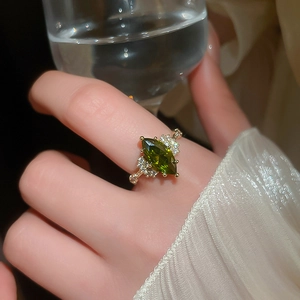 Close-up of a vintage 14K gold plated ring with oval emerald and diamonds on a finger