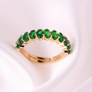 Macro detail of gold plated adjustable ring featuring vibrant green oval zircon stones