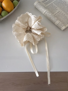 Lace scrunchie with ribbons featuring delicate floral embroidery on a white table