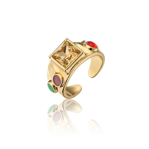 Detailed macro view of 18K gold ring featuring a large square yellow gemstone and accents