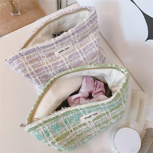 Macro shot of tweed makeup bags in lavender and mint green with simple wish labels