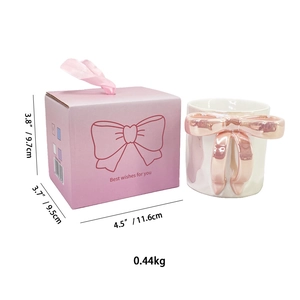 Dettaglio tazza in ceramica bianca con fiocco 3D oro rosa e confezione regalo rosa