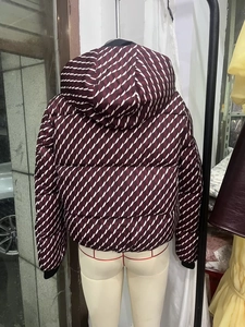 Detail of burgundy hooded puffer jacket with white geometric patterns from the back