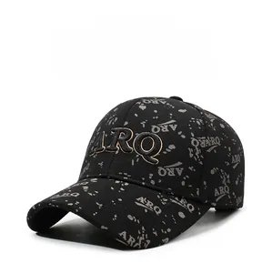 Gros plan sur la broderie 3D dorée ARQ et le motif d'encre sur la casquette de baseball noire
