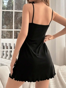 Detail of black camisole dress with lettuce hem finish and silky texture from back view