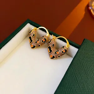 Gold plated heart hoop earrings with leopard enamel finish on a leather box