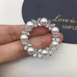 Detail of elegant wreath brooch with freshwater pearls and marquis crystals