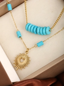 Detail of 14K gold plated necklace with turquoise beads and sunburst heart pendant