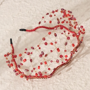Detailed macro of handmade red beaded headband with gold wire mesh and faceted crystals