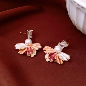 Détail de boucles d'oreilles fleurs vintage avec perle, zircon et émail coloré élégant
