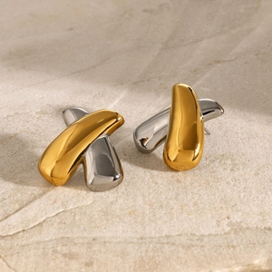 Macro shot of 18k gold and silver two-tone stainless steel X-shaped crossover earrings