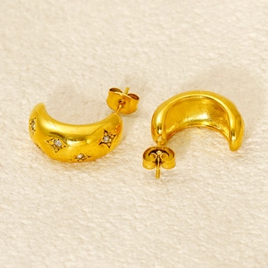 Macro shot of gold stainless steel curved earrings with star-set cubic zirconia accents