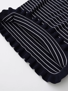 Détail du tissu en maille rayé bleu marine et blanc avec finition bord à volants