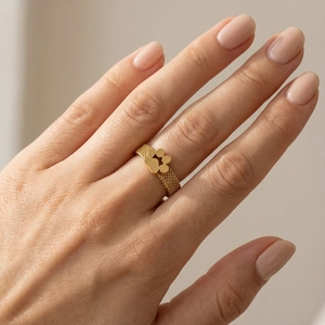 Close-up of a gold mesh band ring with a cute cat paw design worn on a finger