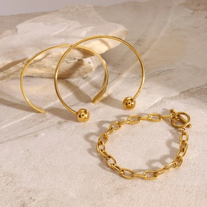 Polierte goldene Edelstahlarmreifen und T-Verschluss-Kette auf Steinsockel