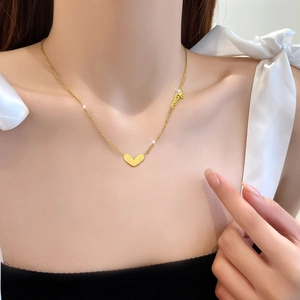 Collana in acciaio al titanio dorato con ciondolo a cuore e dettaglio scritta love