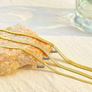 Vue détaillée de colliers chaîne serpent dorée en 2mm, 3mm et 4mm sur support pierre