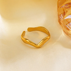 Minimalist gold plated wave open ring on champagne silk and amber glass display