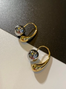 Macro detail of French vintage teardrop earrings with silver ball and gold hook design