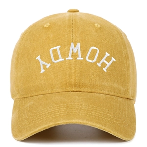 Detail of white 3D Howdy embroidery on washed yellow cotton baseball cap with curved brim