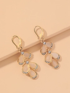 Macro shot of gold leaf earrings with teardrop opals and sparkling rhinestones