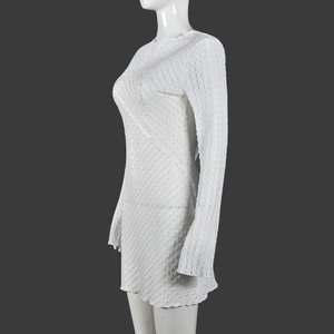 Détail d'une robe courte blanche à manches longues en tissu plissé texturé sur mannequin