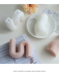 Detailansicht der U-förmigen Wellen-Duftkerzen in Creme und Rosa für Wohndekoration