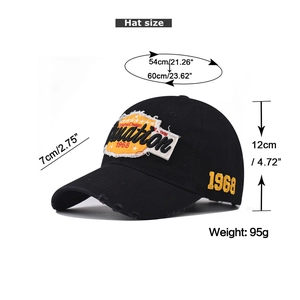 Detailed view of distressed cotton baseball cap with orange embroidery and size dimensions