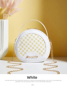 Détail du sac à main rond blanc avec motif circulaire jaune et bandoulière dorée