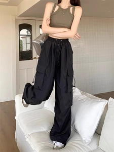 Detail view of black high-waisted cargo pants with side flap pockets and elastic waistband