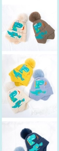 Dettaglio del cappello in maglia con dinosauro per bambini con pompon e paraorecchi