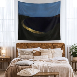 Modern abstract landscape tapestry with deep blue night sky over a cozy bedroom bed