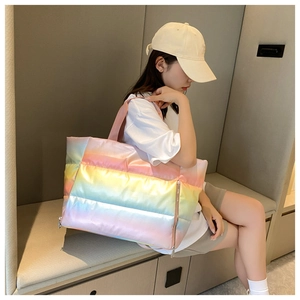 Quilted puffer tote bag in rainbow gradient finish shown in a lifestyle model shot