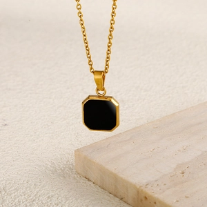 Collana a catena dorata con pendente ottagonale nero su sfondo testurizzato e raffinato