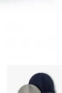 Texture détaillée des bonnets en maille bleu marine et gris clair avec des écussons tissés