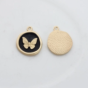Macro shot of gold and black enamel butterfly round charms with textured back view