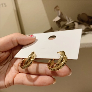 Detail of gold double-layer cross hoop earrings displayed on a white product card