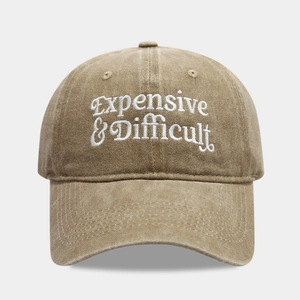 Detail of white 3D embroidery 'Expensive & Difficult' on khaki cotton baseball cap