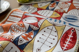 Macro shot of colorful jacquard fish pattern on thick fabric table runner with texture