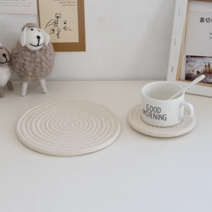 Detailed close-up of beige woven cotton coasters on a table for heat protection