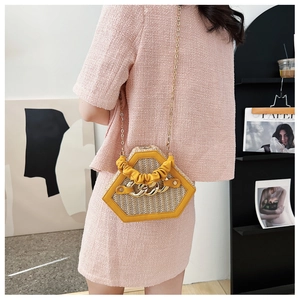 Chic yellow woven hexagonal shell bag with gold chain and handle shown on a model
