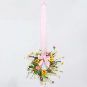 Detailed close-up of handmade Easter wreath with colorful flowers and pink satin bow