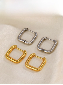 Polished gold and silver square hoop earrings on silk fabric detail display