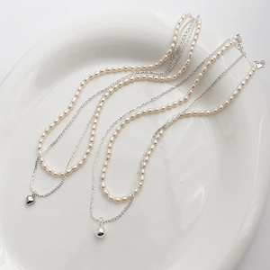 Detail of double-layer necklace with freshwater pearls and S925 silver chains on white plate