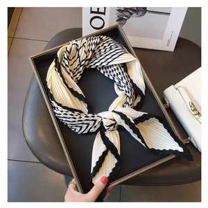 Detail of pleated black and white striped silk scarf featuring geometric patterns