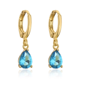 Detail of 18K gold butterfly earrings featuring teardrop blue zircon gemstones