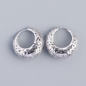 Macro shot of silver S925 sterling silver hoop earrings with intricate hollow patterns