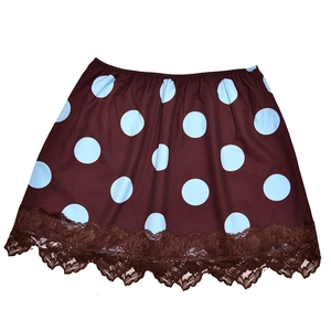 Close-up of brown skirt hem featuring delicate lace trim and light blue polka dot pattern