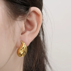 Macro detail of 18K gold plated stainless steel teardrop earrings with hammered texture