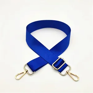 Close-up of royal blue nylon bag strap with polished gold lobster clasps and buckle
